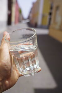 Midsection of person holding glass of water