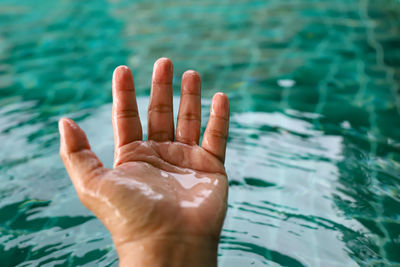 Close-up of person hand in swimming pool