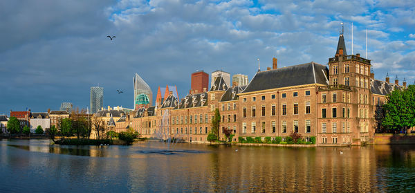 Buildings in city against cloudy sky