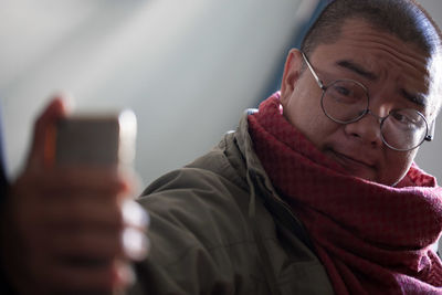 Close-up of man taking selfie with smart phone