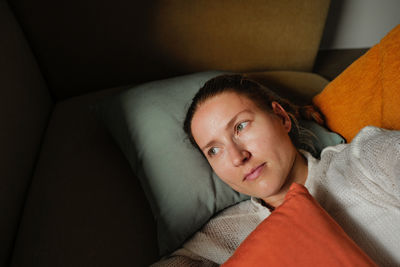 Portrait of young woman sitting on sofa at home