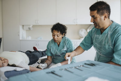 Male and female surgeons operating young patient in hospital