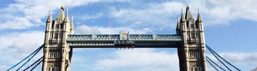 Low angle view of bridge against cloudy sky