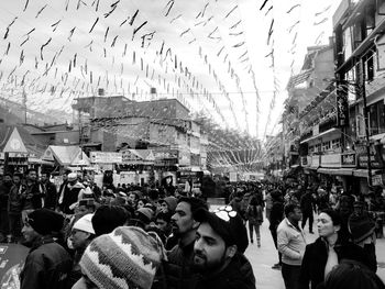 People on street in city against sky