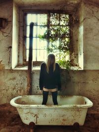 Woman looking away while sitting in bathroom