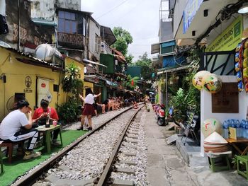 People on railroad tracks in city