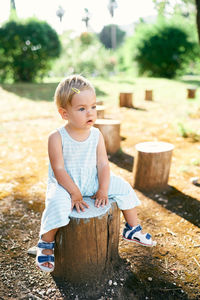 Full length of cute boy sitting outdoors