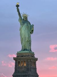 Low angle view of woman standing against sky during sunset