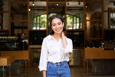 Portrait of young woman standing in store