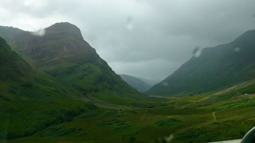 Scenic view of mountains against cloudy sky