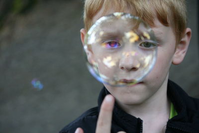 Close-up of boy looking at bubble