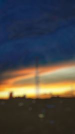 Defocused image of silhouette landscape against sky during sunset
