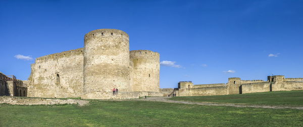 Low angle view of old ruin building against blue sky