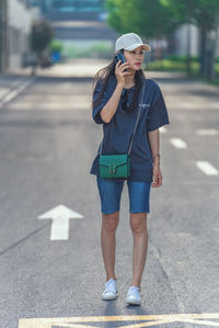 Portrait of young woman standing on road