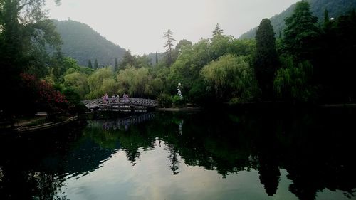 Scenic view of lake by trees against sky