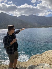 Man standing by sea against mountains