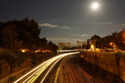 Blurred motion of train moving against sky at night