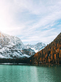 Scenic view of lake by snowcapped mountains against sky, lake braies in autumn.