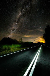 Diminishing perspective of empty road against star field at night