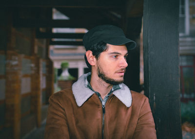Portrait of young man looking away outdoors
