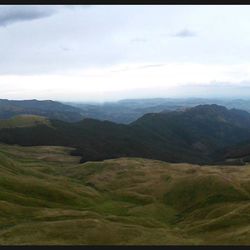 Scenic view of mountains against cloudy sky