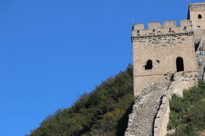 Low angle view of fort against clear blue sky