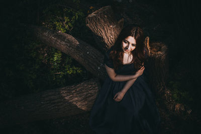 Portrait of smiling young woman in forest at night