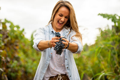 Woman squeezing blueberries at farm