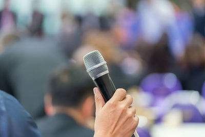 Cropped hand of person holding microphone