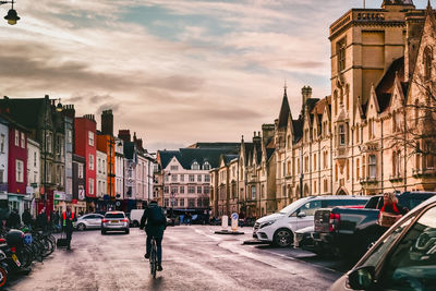 Cars on street amidst buildings in city against sky