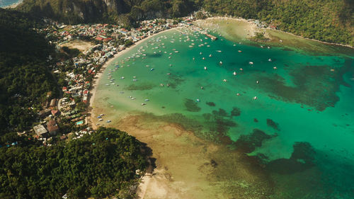 Many boats in the turquoise lagoon near city el nido. seascape with blue bay and boats 