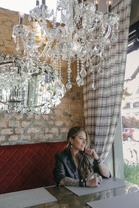 Full length of young woman sitting on table