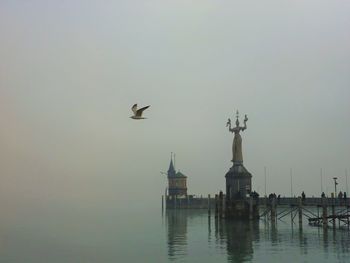 Birds flying over mosque against sky