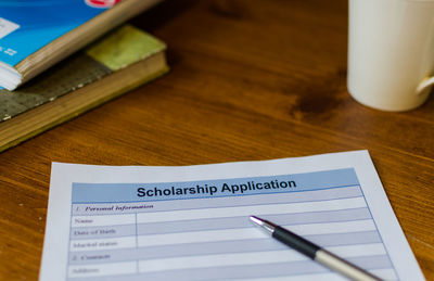 Close-up of scholarship application form with pen on table