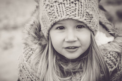 Portrait of a beautiful little girl 4-5 years old close-up in warm clothes and a knitted hat. 