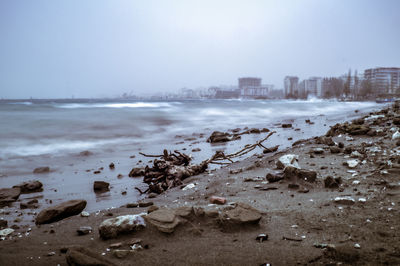 Scenic view of beach by city against sky