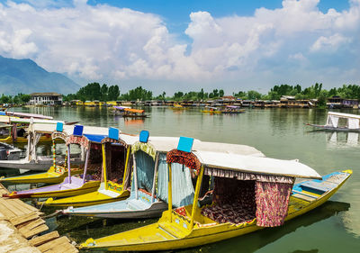 Boats moored in lake against sky