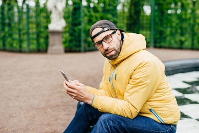 Young man using mobile phone outdoors