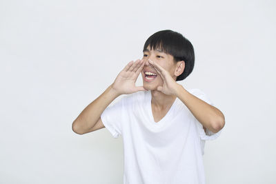 Portrait of boy standing against white background
