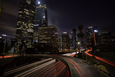 High angle view of illuminated street amidst buildings at night