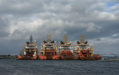 Commercial dock and ships by sea against sky