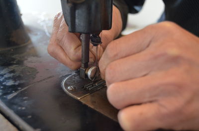 Close-up of man working in sewing machine