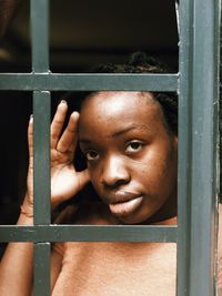 Portrait of baby boy against window in building