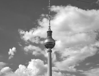 Low angle view of communications tower against cloudy sky