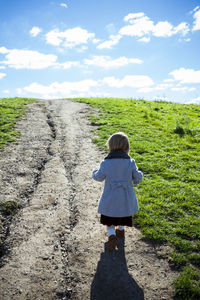 Young stylish girl walking up grassy pathway in detroit mi