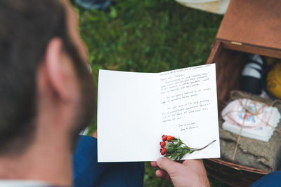 High angle view of man reading greeting card