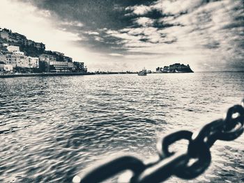 Close-up of chain by sea against sky