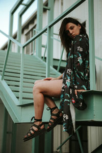 Portrait of woman sitting on staircase