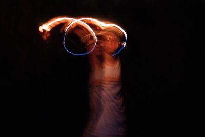 Midsection of shirtless man standing against black background