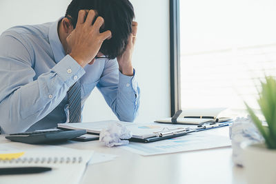 Midsection of man sitting on table